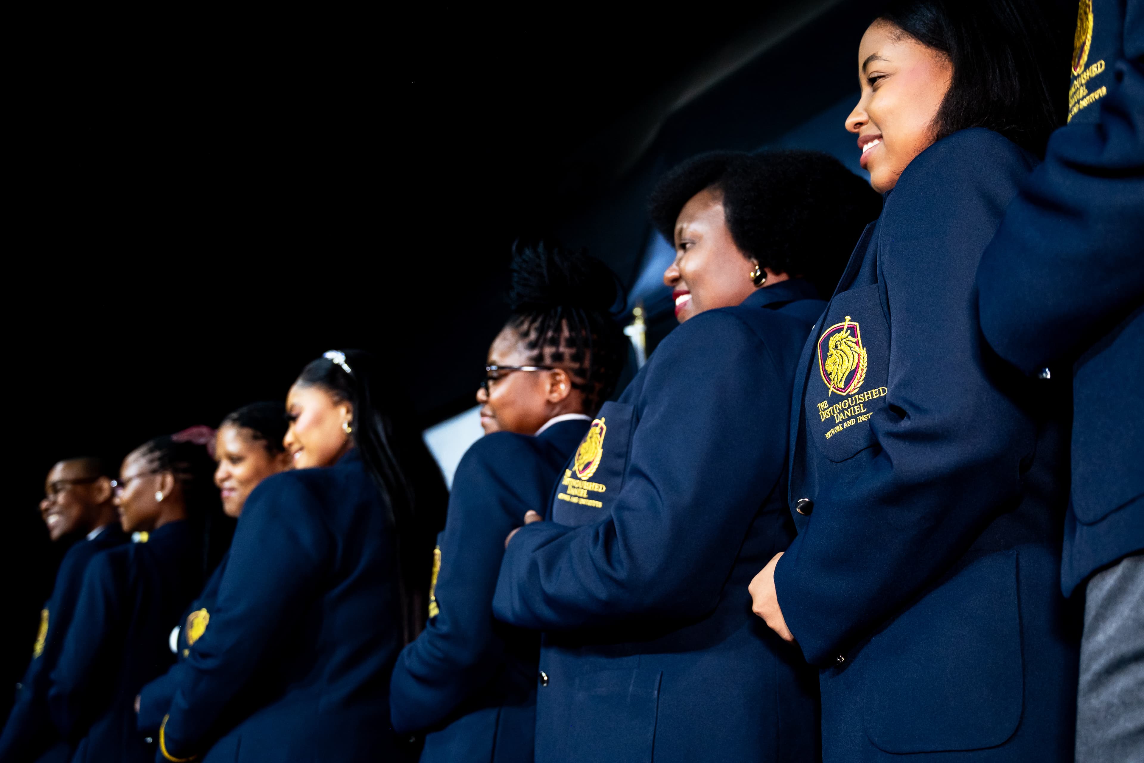 Committee members sharing a candid moment in matching navy jackets